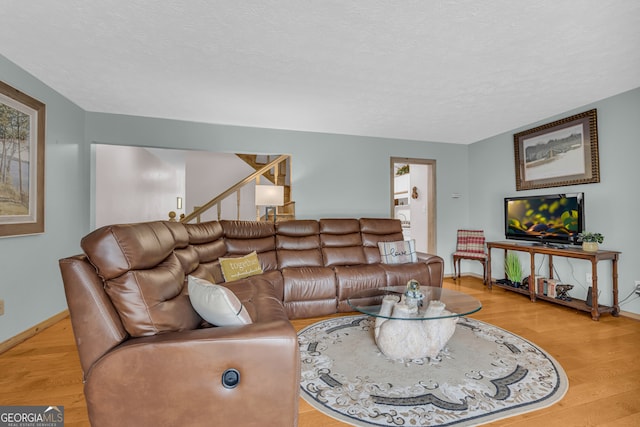 327 Brucken Strasse Unit 609, Helen, GA 30545 - living room with baseboards, light wood-style floors, a textured ceiling, and stairs