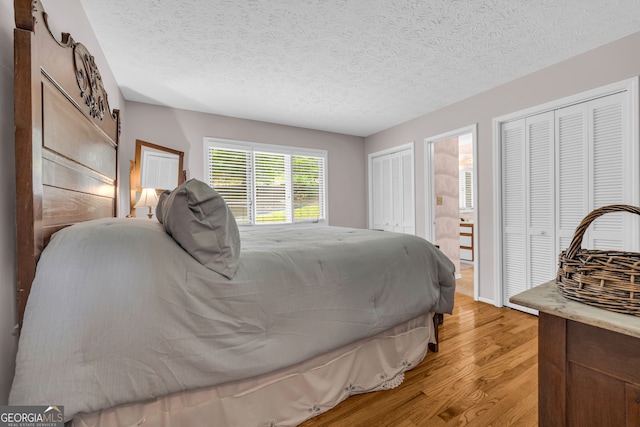 327 Brucken Strasse Unit 609, Helen, GA 30545 - bedroom featuring multiple closets, light wood finished floors, and a textured ceiling