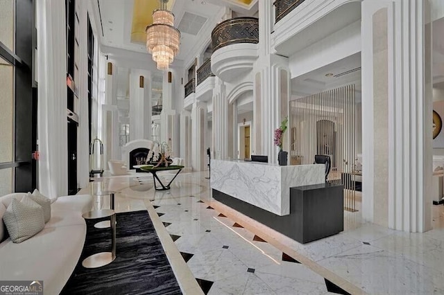 750 Park Ave NE Unit 6E, Atlanta, GA 30326 - reception area featuring ornate columns, a chandelier, a fireplace, and a towering ceiling