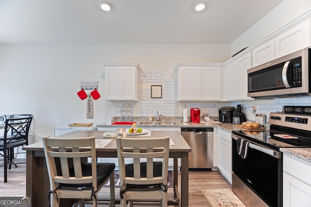 124 Saginaw Ct, Locust Grove, GA 30248 - kitchen with appliances with stainless steel finishes, a sink, decorative backsplash, white cabinets, and recessed lighting