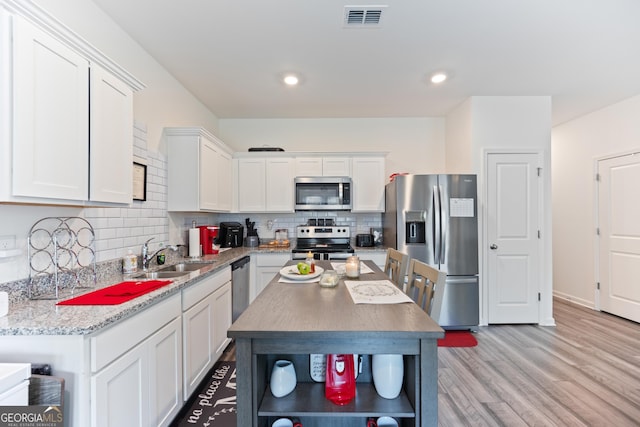 124 Saginaw Ct, Locust Grove, GA 30248 - kitchen featuring appliances with stainless steel finishes, a sink, white cabinetry, decorative backsplash, and open shelves