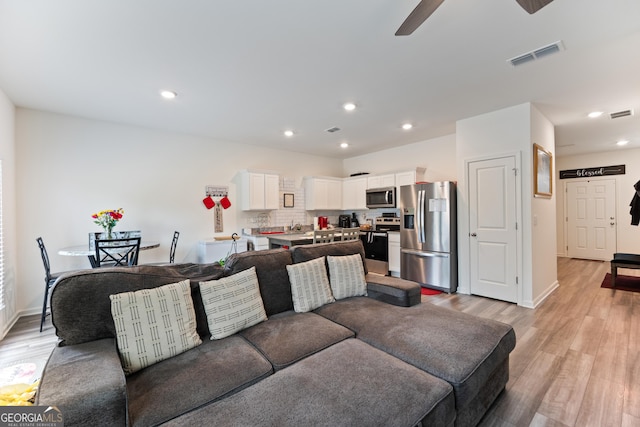 124 Saginaw Ct, Locust Grove, GA 30248 - living area with light wood finished floors, ceiling fan, recessed lighting, and baseboards