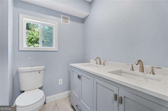 2158 Huckleberry Ln, Lithia Springs, GA 30122 - bathroom featuring double vanity, toilet, marble look tiles, and baseboards