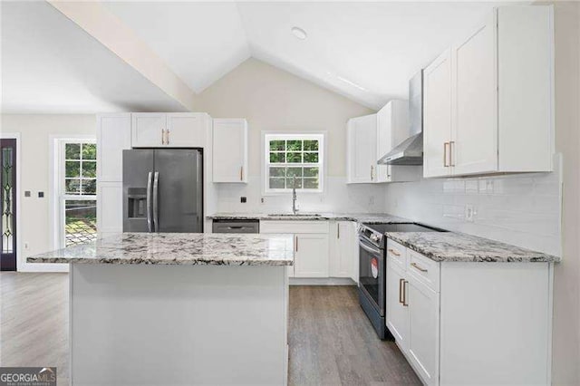 2158 Huckleberry Ln, Lithia Springs, GA 30122 - kitchen with stainless steel appliances, wall chimney range hood, a sink, wood finished floors, and lofted ceiling