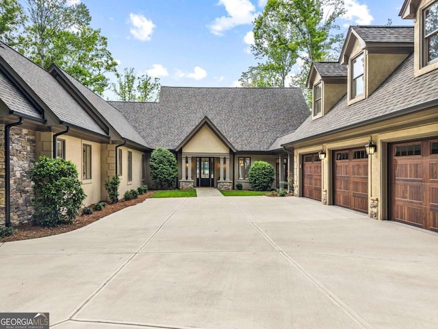 117 W View Way, Eatonton, GA 31024 - view of front facade featuring stone siding, concrete driveway, a shingled roof, stucco siding, and a garage