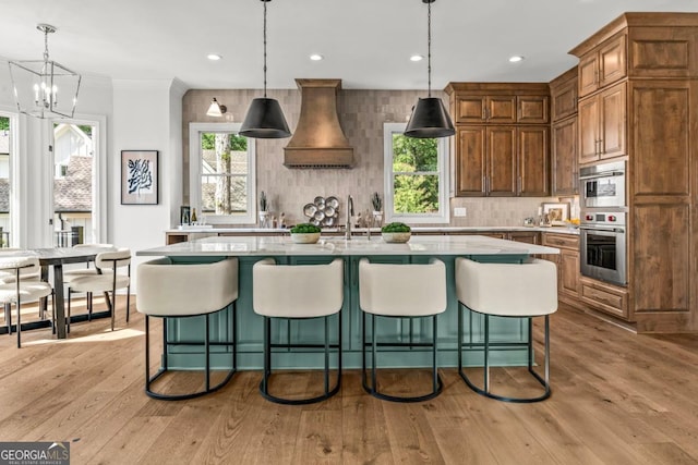 117 W View Way, Eatonton, GA 31024 - kitchen with tasteful backsplash, an island with sink, light wood finished floors, custom exhaust hood, and crown molding