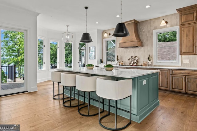 117 W View Way, Eatonton, GA 31024 - kitchen with tasteful backsplash, a kitchen island, light wood-style floors, custom range hood, and a kitchen breakfast bar
