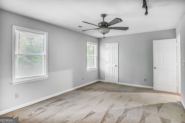 1417 Poplar Pointe SE, Smyrna, GA 30082 - unfurnished bedroom featuring carpet, baseboards, a closet, rail lighting, and a ceiling fan