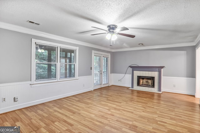 1417 Poplar Pointe SE, Smyrna, GA 30082 - unfurnished living room featuring light wood finished floors, a textured ceiling, wainscoting, a ceiling fan, and a fireplace