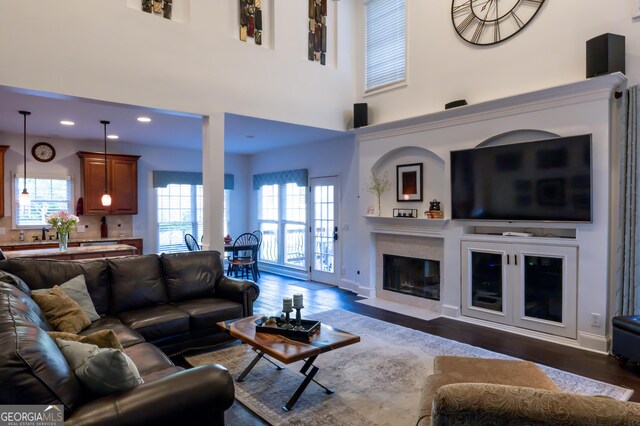8035 Magnolia Way, Roswell, GA 30075 - living room featuring dark wood-style flooring, healthy amount of natural light, a fireplace with flush hearth, a high ceiling, and recessed lighting