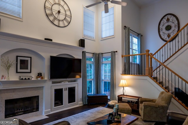 8035 Magnolia Way, Roswell, GA 30075 - living room featuring a towering ceiling, a ceiling fan, a premium fireplace, stairs, and wood finished floors