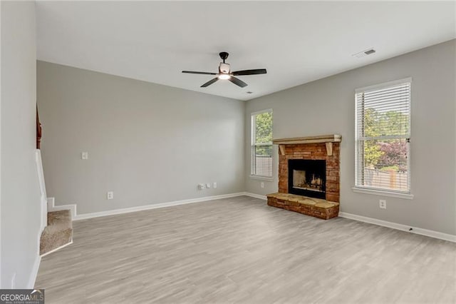 766 Chapman St, Jonesboro, GA 30238 - unfurnished living room featuring light wood-type flooring, baseboards, a ceiling fan, a fireplace with raised hearth, and stairway
