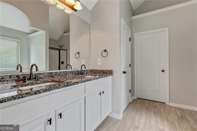 766 Chapman St, Jonesboro, GA 30238 - bathroom featuring vaulted ceiling, a shower stall, wood finished floors, double vanity, and baseboards