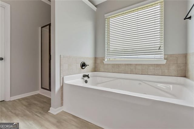 766 Chapman St, Jonesboro, GA 30238 - bathroom with a garden tub, a stall shower, wood finished floors, and plenty of natural light