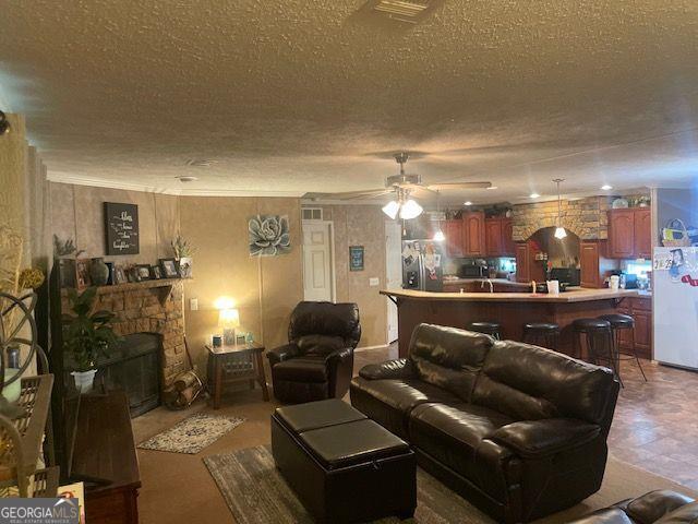 1167 Underwood, Sparta, GA 31087 - living area with a textured ceiling, ceiling fan, and a stone fireplace