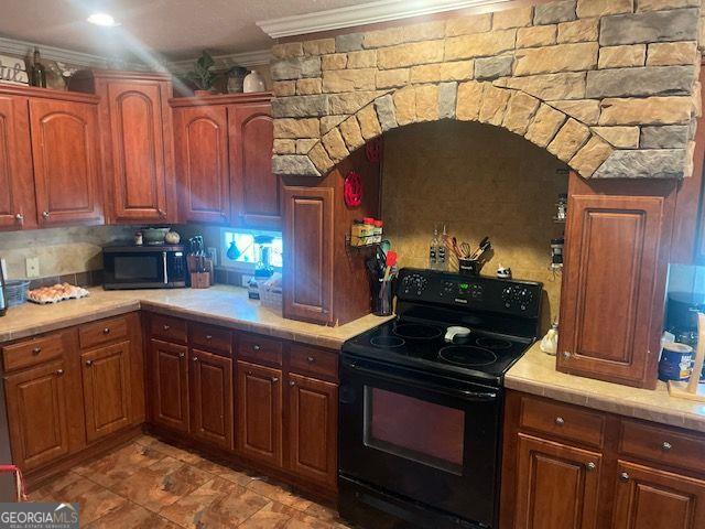 1167 Underwood, Sparta, GA 31087 - kitchen with black range with electric cooktop, ornamental molding, and tile counters