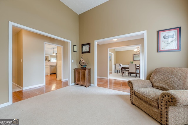 2870 Jay Oak Dr, Dacula, GA 30019 - living area featuring light colored carpet, a chandelier, baseboards, a high ceiling, and light wood-style floors