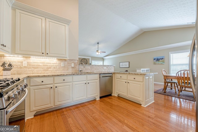 2870 Jay Oak Dr, Dacula, GA 30019 - kitchen with appliances with stainless steel finishes, a peninsula, light wood finished floors, a ceiling fan, and tasteful backsplash