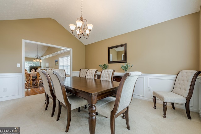 2870 Jay Oak Dr, Dacula, GA 30019 - dining space with a chandelier, vaulted ceiling, wainscoting, light carpet, and a decorative wall
