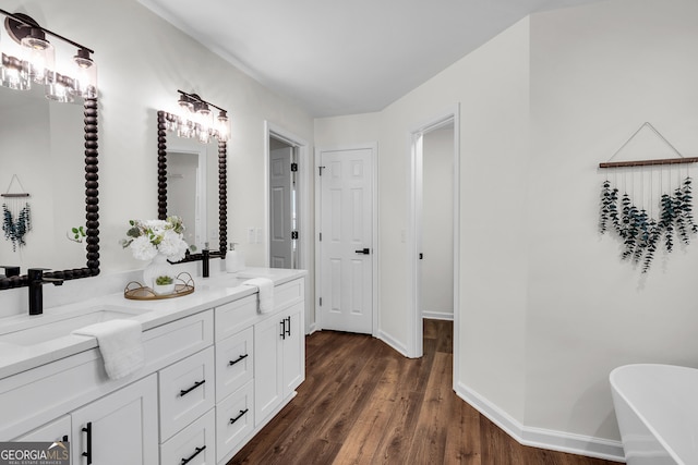 1172 Rockmart Cir NW, Kennesaw, GA 30144 - bathroom featuring double vanity, a freestanding bath, and wood finished floors