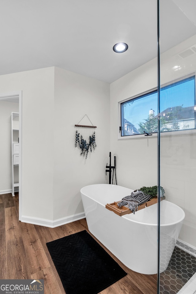 1172 Rockmart Cir NW, Kennesaw, GA 30144 - bathroom with healthy amount of natural light, a soaking tub, and wood finished floors