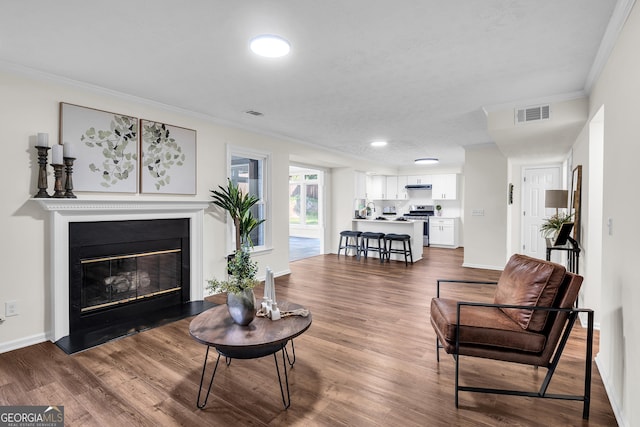 1172 Rockmart Cir NW, Kennesaw, GA 30144 - living room with ornamental molding, a glass covered fireplace, dark wood-style flooring, and recessed lighting