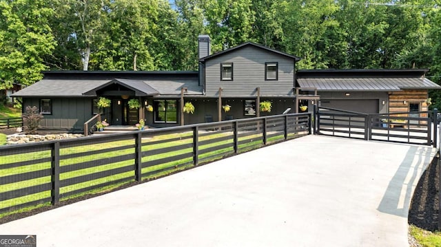 14905 Thompson Rd, Milton, GA 30004 - view of front of home featuring driveway, a fenced front yard, a garage, board and batten siding, and a chimney
