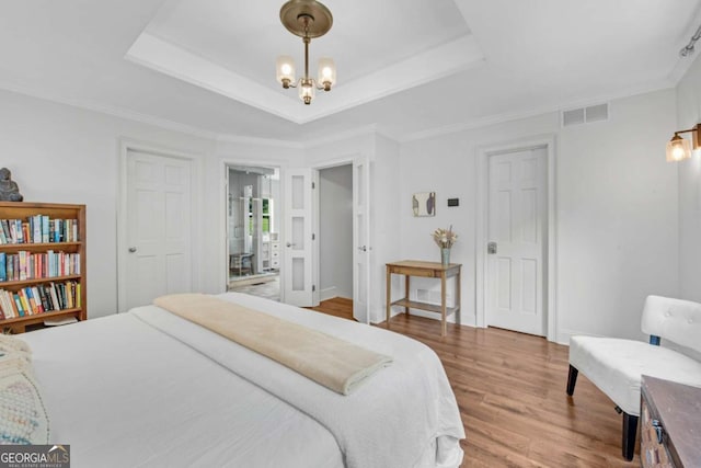 14905 Thompson Rd, Milton, GA 30004 - bedroom with a chandelier, wood finished floors, a tray ceiling, and ornamental molding