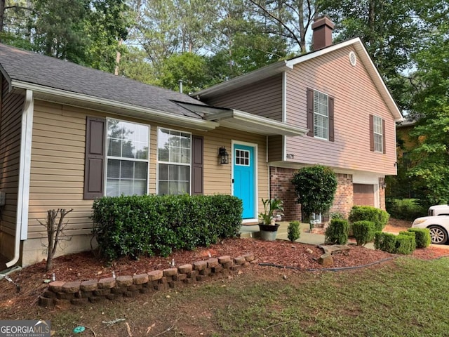 4678 Browns Mill Ferry Rd, Lithonia, GA 30038 - tri-level home featuring a chimney, an attached garage, brick siding, and a shingled roof