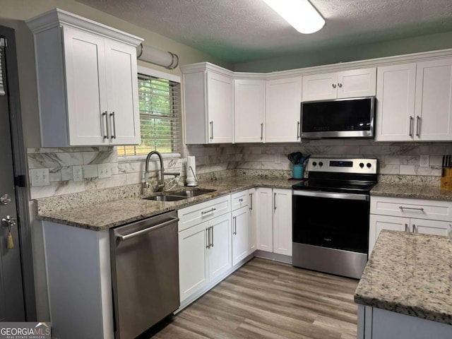 4678 Browns Mill Ferry Rd, Lithonia, GA 30038 - kitchen featuring stainless steel appliances, a sink, white cabinetry, and a textured ceiling