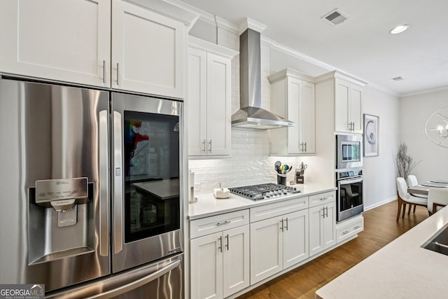 20056 Windalier Way, Roswell, GA 30076 - kitchen featuring appliances with stainless steel finishes, wall chimney range hood, ornamental molding, light countertops, and backsplash