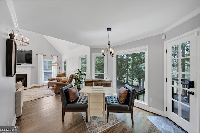 3535 Fairgreen Ct, Douglasville, GA 30135 - dining area featuring a chandelier, wood finished floors, ornamental molding, baseboards, and a fireplace