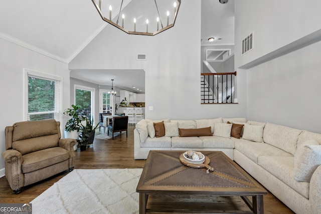 3535 Fairgreen Ct, Douglasville, GA 30135 - living room featuring a chandelier, high vaulted ceiling, ornamental molding, wood finished floors, and stairway