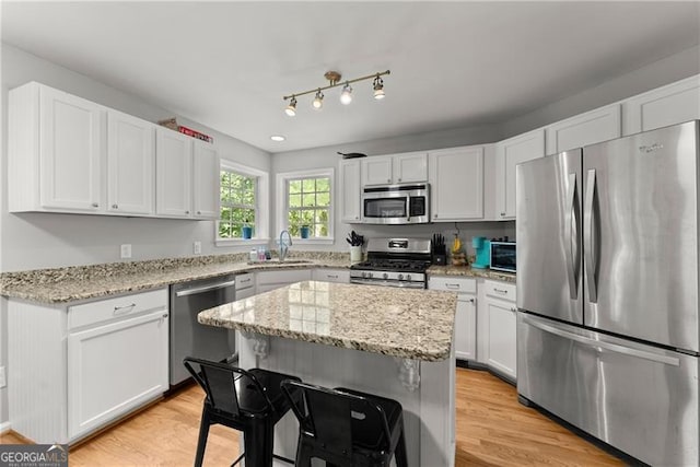 5510 Pilgrim Point Ext, Cumming, GA 30041 - kitchen with appliances with stainless steel finishes, white cabinets, a sink, light wood-type flooring, and light stone countertops