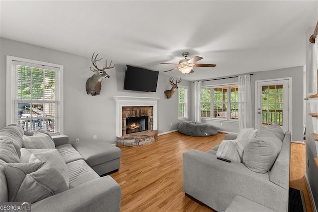 5510 Pilgrim Point Ext, Cumming, GA 30041 - living area featuring a ceiling fan, healthy amount of natural light, a fireplace, and light wood-type flooring