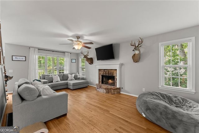 5510 Pilgrim Point Ext, Cumming, GA 30041 - living room with a fireplace, ceiling fan, light wood-style floors, and baseboards