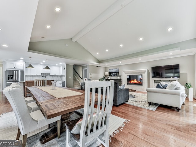 646 Darlington Cir NE, Atlanta, GA 30305 - dining room with stairs, a glass covered fireplace, light wood-type flooring, and recessed lighting