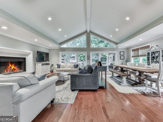 646 Darlington Cir NE, Atlanta, GA 30305 - living area with wood finished floors, lofted ceiling, a warm lit fireplace, recessed lighting, and ornamental molding