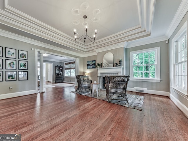 646 Darlington Cir NE, Atlanta, GA 30305 - living area featuring wood finished floors, ornate columns, healthy amount of natural light, a brick fireplace, and ornamental molding