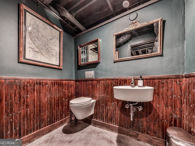 646 Darlington Cir NE, Atlanta, GA 30305 - half bathroom featuring toilet, finished concrete floors, a wainscoted wall, wood walls, and a sink