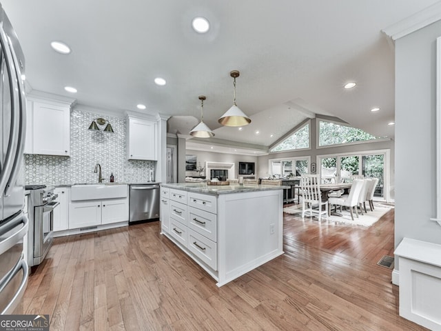 646 Darlington Cir NE, Atlanta, GA 30305 - kitchen featuring appliances with stainless steel finishes, a sink, light wood-style flooring, white cabinets, and tasteful backsplash