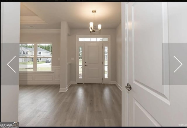 584 Walnut Creek Pkwy, Pendergrass, GA 30567 - entryway with wood finished floors, a chandelier, ornamental molding, and baseboards