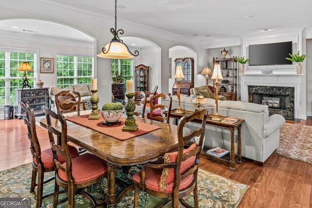 1000 Deep Water Way, Greensboro, GA 30642 - dining area featuring wood finished floors, a high end fireplace, arched walkways, and crown molding