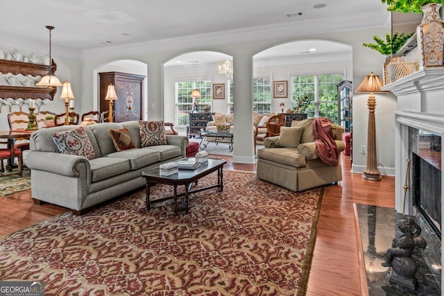 1000 Deep Water Way, Greensboro, GA 30642 - living room featuring a premium fireplace, arched walkways, wood finished floors, and crown molding