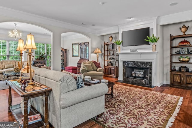 1000 Deep Water Way, Greensboro, GA 30642 - living area featuring a chandelier, a high end fireplace, crown molding, wood finished floors, and arched walkways