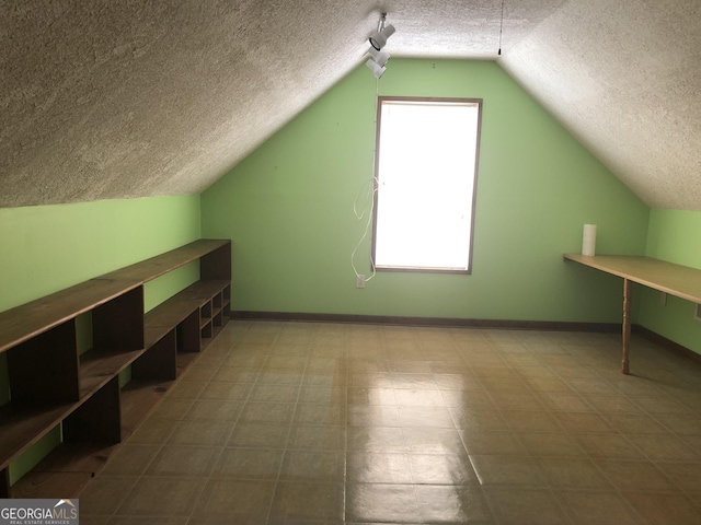 1744 Campbell Rd, Covington, GA 30014 - additional living space featuring a textured ceiling, lofted ceiling, baseboards, and tile patterned floors