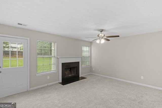 165 Heaton Place Trl, Covington, GA 30016 - unfurnished living room featuring carpet floors, ceiling fan, a fireplace with flush hearth, baseboards, and a textured ceiling