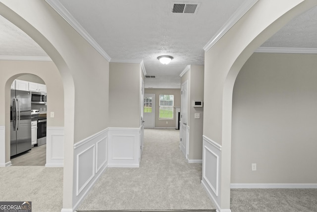 165 Heaton Place Trl, Covington, GA 30016 - hallway with light carpet, a textured ceiling, ornamental molding, and a wainscoted wall