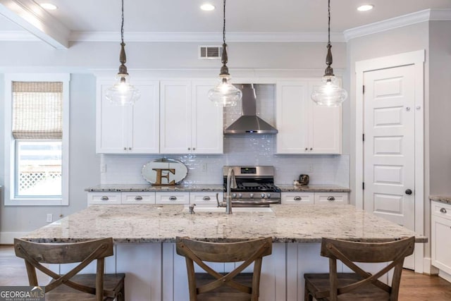 1753 Russell St SE, Atlanta, GA 30316 - kitchen featuring wall chimney exhaust hood, gas range, a kitchen bar, decorative backsplash, and white cabinetry