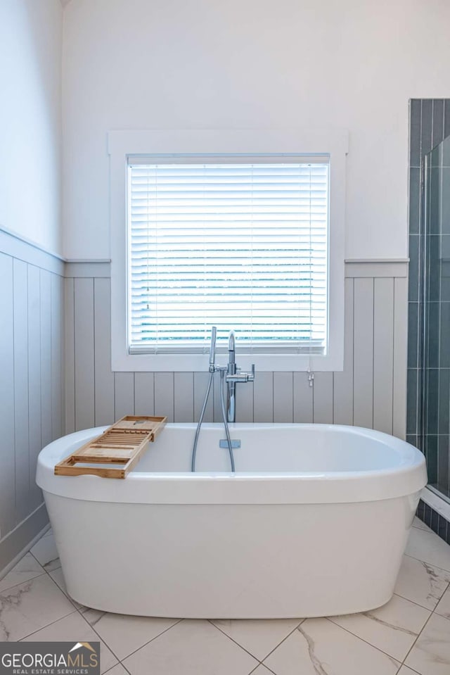 1753 Russell St SE, Atlanta, GA 30316 - bathroom with marble finish flooring, a wainscoted wall, and a soaking tub